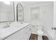 All-white bathroom with double sink vanity, arched mirrors, and modern fixtures at 313 W Church St, Angier, NC 27501