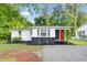 Charming home with red accents, a welcoming front entrance, and a well-maintained yard at 313 W Church St, Angier, NC 27501