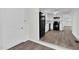 Open concept kitchen featuring white cabinets, modern appliances, and wood-look flooring, flowing into adjoining room at 313 W Church St, Angier, NC 27501