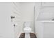 Neat laundry area with stacked washer/dryer, toilet, and storage space, maximizing functionality in a compact area at 313 W Church St, Angier, NC 27501