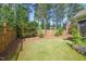 Fenced-in backyard with mature trees and landscaping offers privacy and a serene outdoor space at 320 Trout Valley Rd, Wake Forest, NC 27587