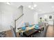 Hardwood floors, gray chairs, dark table, staircase, and a view into the kitchen create an inviting dining space at 34 Schoolhouse Way, Clayton, NC 27520