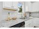 Bright kitchen features white cabinets, granite countertops, stainless steel sink and a view of the backyard at 34 Schoolhouse Way, Clayton, NC 27520