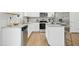 Modern kitchen featuring stainless steel appliances, granite countertops, white cabinets, and hardwood floors at 34 Schoolhouse Way, Clayton, NC 27520