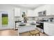 Modern kitchen with stainless steel appliances, granite countertops, and white cabinets at 34 Schoolhouse Way, Clayton, NC 27520