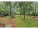 Spacious backyard with mature trees, small storage shed, and an inviting seating area at 3420 Greenville Loop Rd, Wake Forest, NC 27587