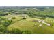 Picturesque aerial view showcases a rural property with sprawling lawns and a home nestled amongst mature trees at 3465 Covington Trl, Mebane, NC 27302