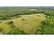 Expansive property featuring multiple homes, outbuildings, and vast green spaces surrounded by lush woodlands at 3465 Covington Trl, Mebane, NC 27302