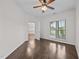 Hardwood bedroom with a partially open door leading to another room with chandelier lighting and a scenic window view at 3465 Covington Trl, Mebane, NC 27302
