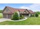 Traditional home featuring a brick and vinyl exterior, a two-car garage, and beautifully landscaped yard at 3465 Covington Trl, Mebane, NC 27302