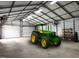 Spacious garage featuring a tractor, work lights, and a metal frame at 3465 Covington Trl, Mebane, NC 27302