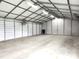 Bright garage interior with metal frame, concrete floor, industrial lighting, and wall-mounted fans at 3465 Covington Trl, Mebane, NC 27302