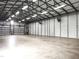 Spacious garage interior with metal framing, concrete floor, industrial lighting, and wall-mounted shelving at 3465 Covington Trl, Mebane, NC 27302