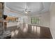 Open-concept living room featuring hardwood floors, a stone fireplace, and a view into the kitchen area at 3465 Covington Trl, Mebane, NC 27302