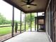 Covered screened porch with a ceiling fan and peaceful views of the surrounding landscape at 3465 Covington Trl, Mebane, NC 27302