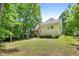 Spacious backyard showcasing lush grass, mature trees, a firepit, deck, and the home's exterior at 347 Manchester Trl, Clayton, NC 27527