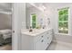 Bright bathroom featuring dual sinks, modern fixtures, and a window overlooking outside at 347 Manchester Trl, Clayton, NC 27527