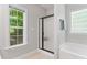 Bathroom featuring a frosted glass shower stall and a soaking tub under a glass block window at 347 Manchester Trl, Clayton, NC 27527