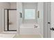 Bathroom featuring a soaking tub with a glass block window for natural light at 347 Manchester Trl, Clayton, NC 27527