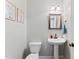 This half-bathroom boasts a pedestal sink, a framed mirror, and tasteful decor at 347 Manchester Trl, Clayton, NC 27527