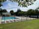 Community pool area featuring lounge chairs, umbrellas, and a fenced perimeter in a park-like setting at 347 Manchester Trl, Clayton, NC 27527