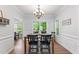 Dining room with wainscoting, chandelier, two windows, and adjacent doorway at 347 Manchester Trl, Clayton, NC 27527