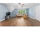 Cozy living room with hardwood floors, comfortable sofa, and natural light from the windows at 347 Manchester Trl, Clayton, NC 27527