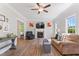 Bright living room with fireplace, ceiling fan, wood floors, neutral colors, and ample natural light at 347 Manchester Trl, Clayton, NC 27527