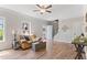 Living room with wood floors, neutral walls, ceiling fan, and entry door with blue trim at 347 Manchester Trl, Clayton, NC 27527