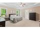 Spacious main bedroom featuring a tray ceiling, plush carpet, and ensuite bathroom at 347 Manchester Trl, Clayton, NC 27527