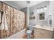 Neutral bathroom featuring a shower with patterned curtain, vanity, toilet, mirror, and neutral paint at 4 Barkridge Ct, Durham, NC 27713
