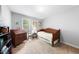 Neutral bedroom with carpeted floors features a twin bed with a light-colored comforter, desk, and dresser at 4 Barkridge Ct, Durham, NC 27713