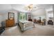 Carpeted bedroom featuring two windows, a ceiling fan, dresser, a bed, and an accent chair at 4 Barkridge Ct, Durham, NC 27713