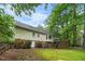 Rear exterior of house with yard, deck, and mature trees at 4 Barkridge Ct, Durham, NC 27713
