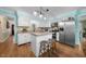 Bright kitchen features white cabinets, granite countertops, stainless steel appliances, and an island with barstool seating at 4 Barkridge Ct, Durham, NC 27713