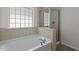This bathroom features a tub and shower, a glass window, and neutral paint at 4003 Jockey Club Cir, Cary, NC 27519