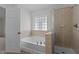 This bathroom features a tub and shower, a glass window, and neutral paint at 4003 Jockey Club Cir, Cary, NC 27519