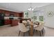 A dining area with a table set for six next to a bright kitchen with dark wood cabinets at 4003 Jockey Club Cir, Cary, NC 27519