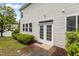 Home's exterior features a back entrance with glass doors and manicured landscaping at 4003 Jockey Club Cir, Cary, NC 27519