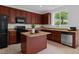 An inviting kitchen with dark wood cabinets, island and stainless steel appliances at 4003 Jockey Club Cir, Cary, NC 27519