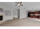Open living space with hardwood floors, fireplace and a ceiling fan, next to a modern kitchen at 4003 Jockey Club Cir, Cary, NC 27519
