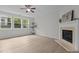 Cozy living room featuring hardwood floors, a ceiling fan, a fireplace, and large windows at 4003 Jockey Club Cir, Cary, NC 27519