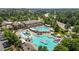 Aerial view of a luxurious community pool with multiple pools, slides, and a clubhouse surrounded by lush greenery at 4003 Jockey Club Cir, Cary, NC 27519