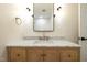 Stylish bathroom with wood cabinets, marble countertop, and updated lighting at 4012 Castle Ct, Raleigh, NC 27613