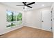 Bright bedroom with hardwood floors, ceiling fan, and large window with street view at 4012 Castle Ct, Raleigh, NC 27613