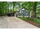 Stylish gray home with carport, complemented by mature trees, and a long, inviting driveway at 4012 Castle Ct, Raleigh, NC 27613