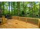 A wooden deck features a built-in bench seating surrounded by a lush tree canopy at 4012 Castle Ct, Raleigh, NC 27613