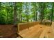 Large wooden deck surrounded by lush green trees for a private and relaxing outdoor space at 4012 Castle Ct, Raleigh, NC 27613