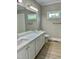 Bathroom featuring double sinks, quartz countertop, vinyl flooring, and a window for natural light at 4016 Berman Edge Rd, Holly Springs, NC 27540