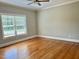 Neutral bedroom with hardwood floors, crown molding, a ceiling fan, and a bright window at 4016 Berman Edge Rd, Holly Springs, NC 27540